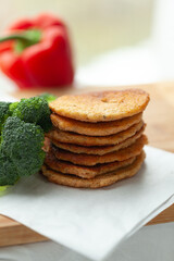 Stack of savory pancakes with broccoli and a red bell pepper.