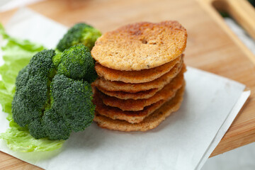 Stack of savory pancakes with fresh broccoli florets. Healthy and delicious meal or snack option.