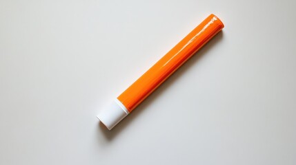 Orange adhesive glue stick on a light beige background with ample copy space for text placement