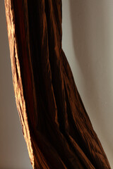 Draped brown fabric with rich texture and deep shadows. Luxurious textile detail.