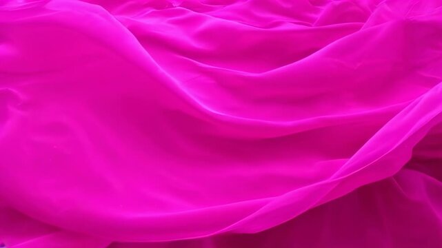 Vibrant Pink Fabric Texture: A rich, fuchsia pink fabric drapes elegantly, showcasing its luxurious texture and vibrant color. The folds and creases create a dynamic and visually appealing image.