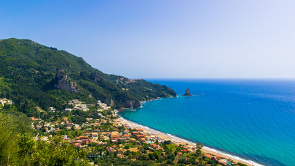 Fototapeta premium Panoramic view of Agios Gordios bay with sandy beach, small village and turquoise sea on Corfu island, Greece