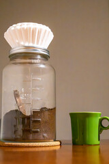 Solomons, Maryland, USA A glass jar with coffee grinds and filter sitting on top.