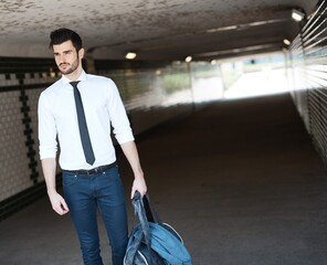 Young man walking in underpass.