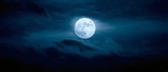 Fototapeta premium A full moon with faint clouds, casting an eerie glow