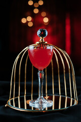 red cocktail on black table in night club