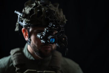 A special forces soldier using night vision monocular and thermal imaging device in the darkness.