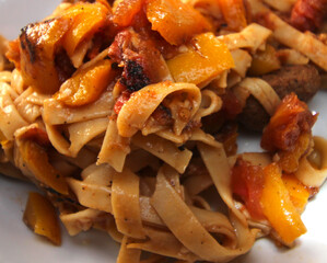 pasta with bell peppers, tomatoes and meat. meal details. meal with selective focus.