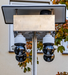 A black and white photo of a pole with four cameras on it