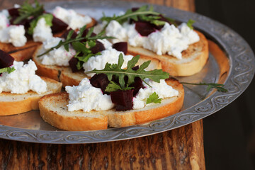 Sandwiches with feta cheese, beets and arugula on rustic table background. Healthy breakfast or snack