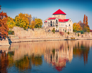 Obraz premium Calm autumn view of Tata Castle - 14th-century castle and museum with restored rooms and garden. Wonderful morning cityscape of Tata town on the shore of Tatai lake, Hungary, Europe.