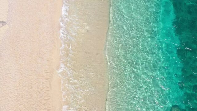 turquoise sea waves flowing on the coast, clear blue water on the beach from above