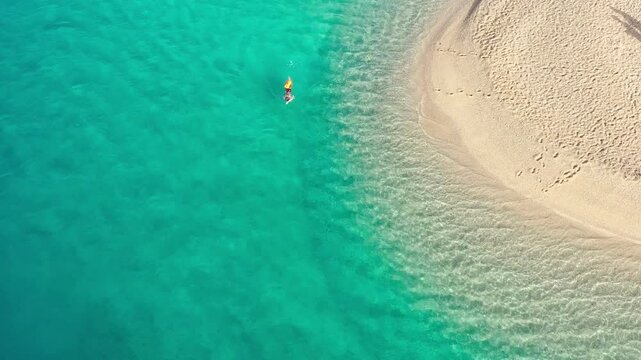 Person swims in the turquoise sea at Zlatni Rat, the most famous beach in Croatia