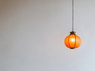 Orange Hanging Lantern Against A Plain White Wall