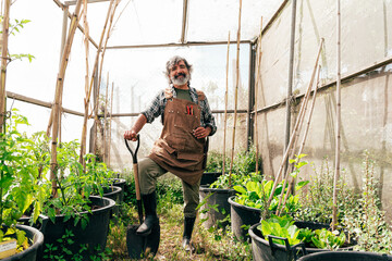 Farmer senior man working in his farm and greenhouse. Concept about agriculture, farn industry, and...