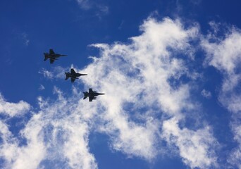 Three F16 Military fighter jets flying overhead