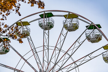 A large white and yellow Ferris wheel with a green top