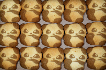 Panda-shaped cookies spread out on kraft paper