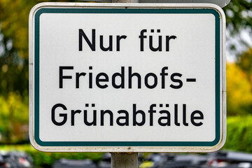 A sign with the word Friedhofs-Grunabfallle written on it