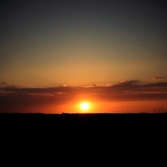 Fiery sunset over silhouetted landscape.