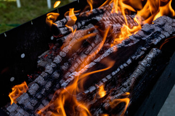 Burning firewood on the barbecue, in close-up