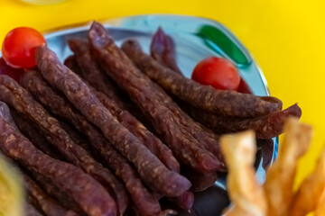 Savory traditional delicacy served on a metallic plate with colorful accompaniments at a local eatery