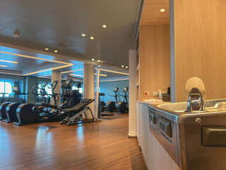 Obraz premium Moderne Fitnessgeräte und Kraftmaschinen in Sportstudio auf Kreuzfahrtschiff - Modern cardio and weight equipment in fitness center gym onboard cruiseship cruise ship ocean liner