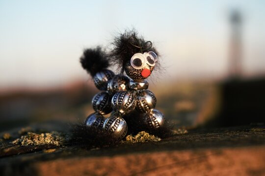 Creative hobby object made of beads that resembles an animal. A dog or cat as a pet that is looking for an owner with a red nose and big eyes.