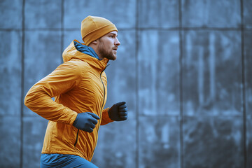 A man in a yellow jacket and hat runs on a concrete sidewalk. Generative Ai.