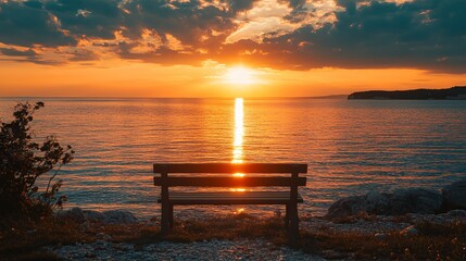 A bench is sitting on the beach next to the ocean