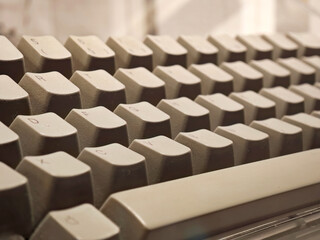 Obraz premium Close-up of a simple vintage beige tone computer keyboard, retro style PC keys with shallow depth of field, classic technology concept, macro detail of old computing hardware, beige nostalgic design