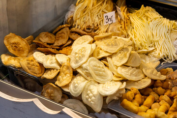 Traditional Polish oscypek cheese in store display, assortment of smoked and fresh cheese, regional delicacies in the store fridge, Polish culinary traditional food market detail closeup, nobody