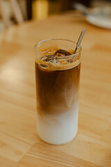 Iced coffee in a tall glass on a table