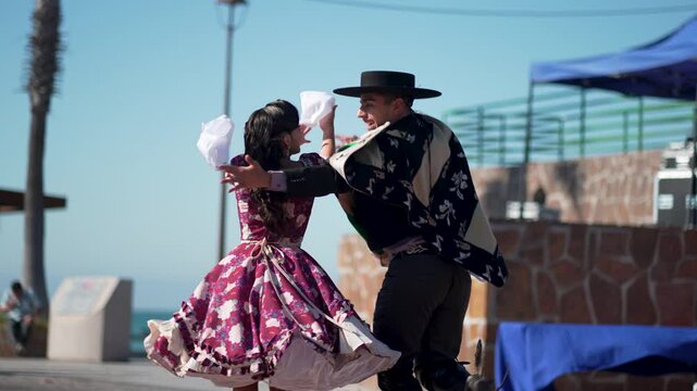 Chilean dancers performing cueca, the national dance of chile, with handkerchiefs, wearing traditional clothing