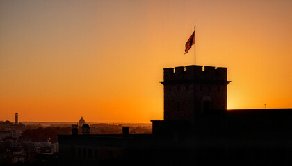 Fototapeta premium Bastille guard tower silhouette against setting sun, historical significance
