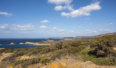 Naklejka premium Landscape of the south-west coast of Sardinia with cliffs, blue sea, fjords and white clouds