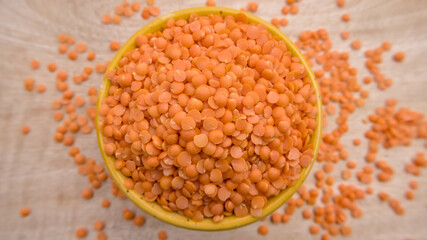 Red Lentils (Masoor Dal) Split and Dehusked in a Yellow Bowl - Rustic Close-Up Top View Flat Lay