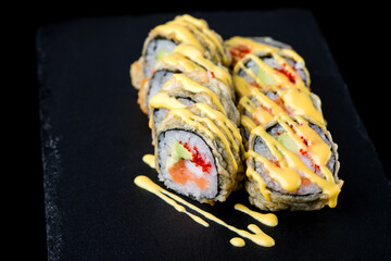 Set of sushi rolls on a black matte plate.
Sushi set on a black matte plate.
Japanese traditional sushi dish. A beautiful dish for an Asian restaurant menu.