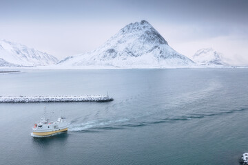 Fishing boat in the fjord. Aerial view of Lofoten Islands, Norway. Industrial fishing. View from a drone. Aerial landscape. Mountains and water. Image of Norway