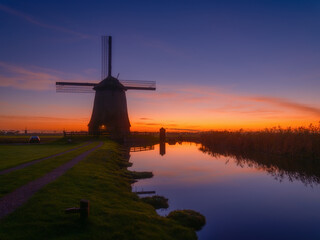 Windmill in the Netherlands. Historical buildings in the Netherlands. Reflections on the surface of water. Image for postcards, background, design.