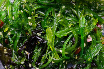 Green Chuka seaweed salad isolated on white background, top view. Wakame seaweed salad, Chuka seaweed, healthy seaweed food