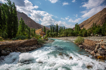 A river with a bridge over it and a house in the background