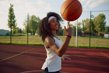 Attractive basketball player spinning ball on finger showing trick