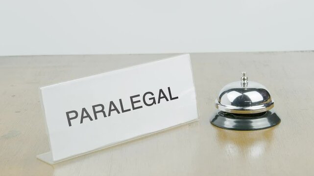 Paralegal Office or Room with Hand Ringing The Bell on Desk or Table Multiple Times