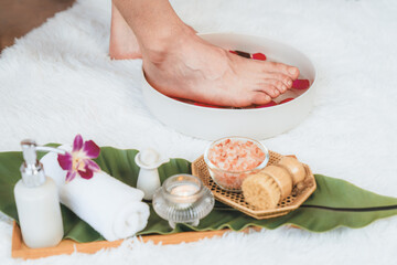 Woman indulges in blissful foot massage at luxurious spa salon while masseur give reflexology therapy in gentle day light ambiance resort or hotel foot spa. Quiescent