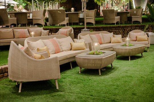 Elegant outdoor lounge area with wicker furniture, plush cushions, and soft lighting. Perfect for relaxation and socializing.