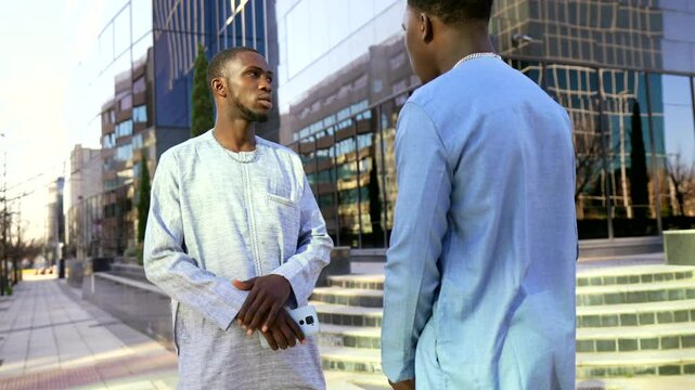 Senegalese businessmen discussing near office building