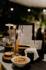 Evening bar snacks: peanuts, breadsticks, and a creamy dip await.