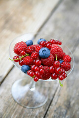 Raspberries, Japanese wineberries (Rubus phoenicolasius) and blueberries in a champagne glass