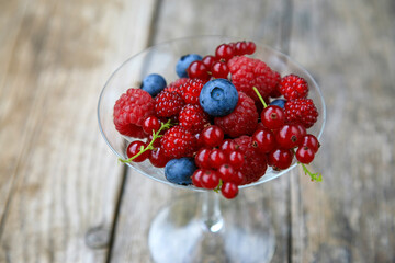 Raspberries, Japanese wineberries (Rubus phoenicolasius) and blueberries in a champagne glass
